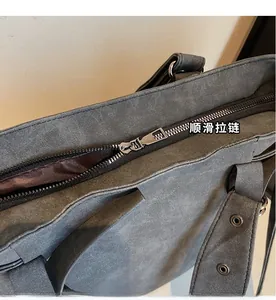 Detailansicht des Metallreißverschlusses und Innenfutters einer grauen Velourtasche
