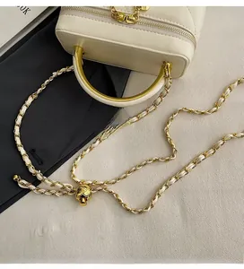 Quilted mini crossbody bag detail showing gold metal handle and adjustable chain strap