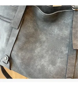 Nahaufnahme der grauen Wildledertextur mit Reißverschluss am Vintage-Damenrucksack