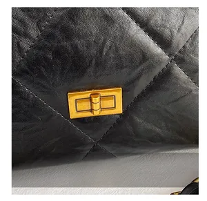 Detail of black quilted leather shoulder bag with gold-tone rectangular turn-lock