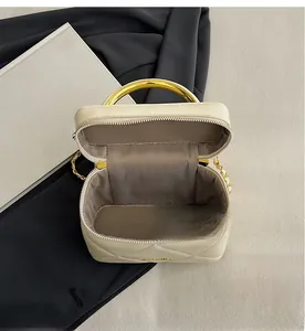 Interior view of quilted cream handbag with gold handles and gray lining detail