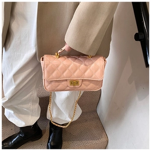 Close-up of pink quilted leather bag with gold chain strap and metal turn-lock