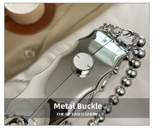 Detail of silver wavy evening bag featuring a secure metal clasp and beaded chain