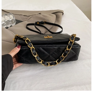Detail of classic quilted embroidery on black leather crossbody bag with chain strap