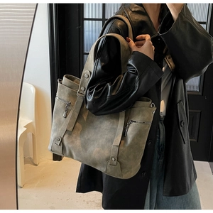 Details der grauen Retro-Tasche mit matter Textur, Seitenreißverschluss und Nieten