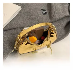 Detail showing internal capacity of gold mirror finish handbag with chain strap