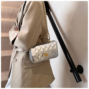 Close-up of silver quilted crossbody bag featuring gold chain strap and metal lock