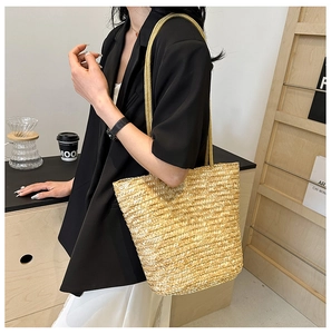 Detail of straw woven bucket bag styled with an elegant outfit for summer vacation