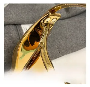 Close-up of golden metallic zipper closure on glossy patent leather mini handbag