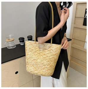 Detail of hand-woven straw tote bag with shoulder strap for summer vacation style