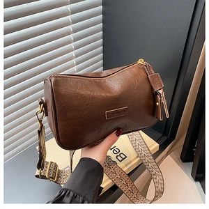Détail du sac vintage marron avec bandoulière tissée aux motifs géométriques