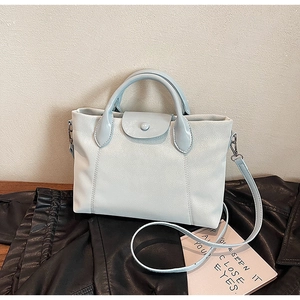 Minimalist light blue faux leather handbag with top handle and crossbody strap