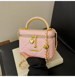 Pink quilted mini bag featuring a gold heart pendant and round metal top handle detail