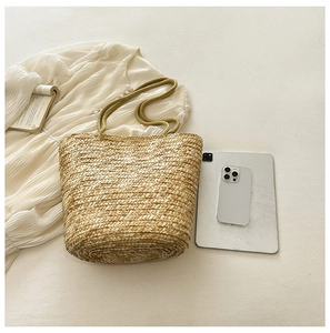Macro shot of natural straw texture and woven rope handles of a summer bucket bag