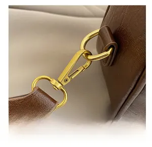Vue détaillée de la ferronnerie en bronze vintage et des coutures sur un sac en cuir marron