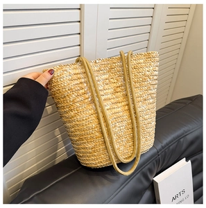 Detail of hand-woven straw tote with thick cotton rope handles for summer vacations