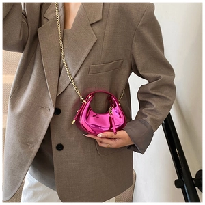 Detail view of mini metallic magenta crescent bag with golden chain and glossy finish