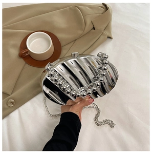Detail of silver metallic fan-shaped evening bag with pleated texture and beaded handle