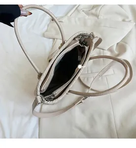 Dettaglio interno della borsa tote intrecciata beige con scomparto centrale a zip