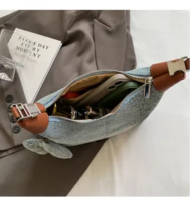 Detail of blue denim crescent bag showing spacious interior for phone and cosmetics