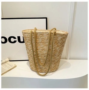 Detail of hand-woven straw tote bag with fine texture and durable long handles
