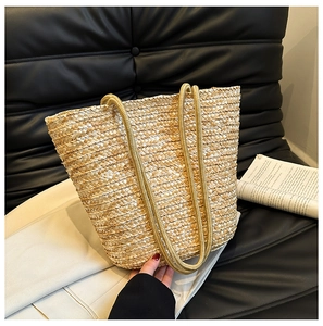 Detailed close-up of woven straw tote bag texture and rope handles on a sofa