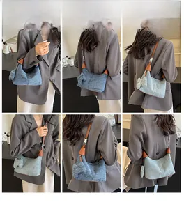 Detail view of denim blue shoulder bag with leather trim and decorative side bow accents