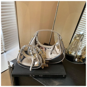 Detailed view of glossy silver metallic mini crescent bags in two sizes with chain straps