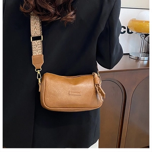 Détail de la texture cuir caramel et plaque FASHION avec bandoulière tissée