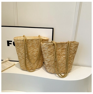 Detail of woven straw bucket bags in two sizes with round braided shoulder straps