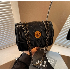 Détail du sac bandoulière en cuir matelassé noir avec fermoir doré et bandoulière chaîne