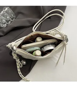 Spacious interior of beige dumpling bag showing zipper pocket and daily essentials storage