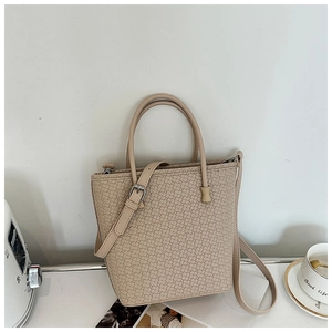 Dettaglio borsa tote beige con trama intrecciata, doppi manici e tracolla regolabile