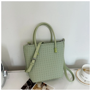 Dettaglio della borsa tote verde chiaro con trama intrecciata e hardware argento