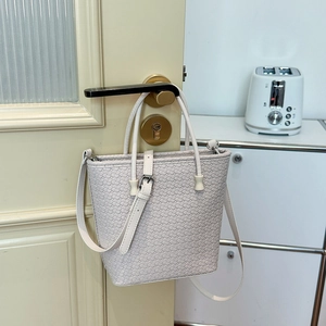 Dettaglio della borsa a mano intrecciata bianco sporco con tracolla regolabile e dettagli argento
