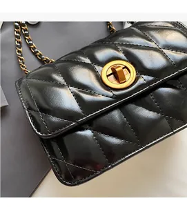 Détail d'un sac bandoulière matelassé noir avec fini brillant et fermoir doré