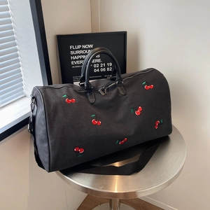 Black canvas tote bag with cherry embroidery and leather handles for travel