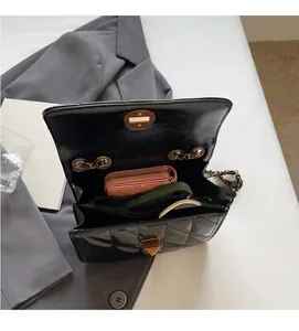 Vue de dessus des compartiments intérieurs de ce sac bandoulière matelassé noir à chaîne