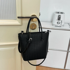 Dettaglio della borsa tote in pelle intrecciata nera con tracolla regolabile e fibbia argento