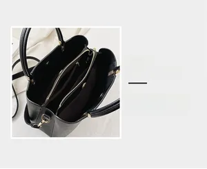 Detailed view of the multi-compartment interior and gold hardware of the black tote bag