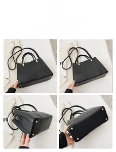 Detailed views of a black crocodile-patterned tote bag with golden protective metal feet