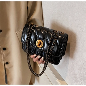 Détail du sac bandoulière en cuir noir matelassé avec fermoir doré et chaîne