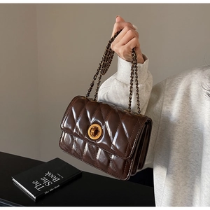 Détail du sac bandoulière matelassé marron foncé avec fermoir doré et bandoulière