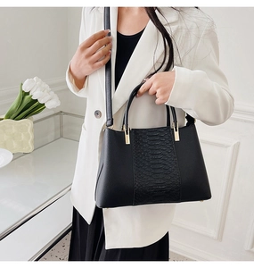 Detail of crocodile embossed faux leather tote bag with elegant golden hardware