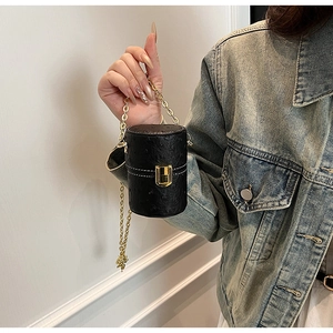 Détail du mini sac cylindre noir à motif autruche avec chaîne dorée et fermoir