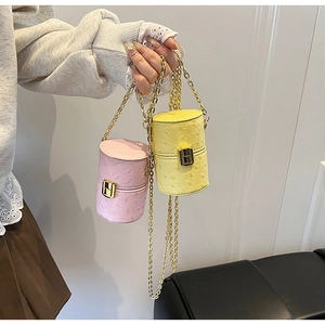 Détail de mini sacs cylindres motif autruche rose et jaune avec chaîne dorée