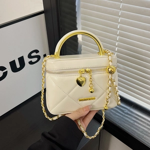 Quilted cream mini handbag with golden circular handle and heart charm detail