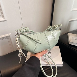 Mint green crinkled patent leather dumpling bag with knotted shoulder strap and knot charm