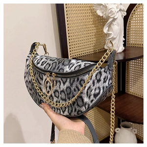 Detail of leopard print crescent bag with golden chain strap and textured fabric finish