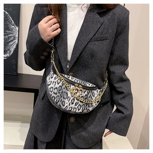 Detail of leopard print crossbody bag with gold chain strap on a grey blazer suit
